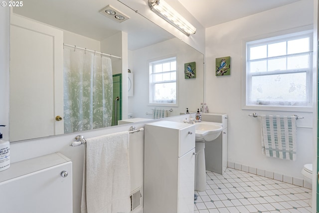 full bath with toilet, a shower with curtain, and a sink