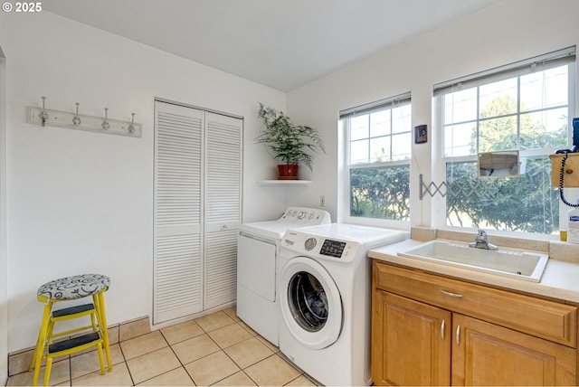 laundry room with cabinet space, a sink, washer and clothes dryer, and light tile patterned floors