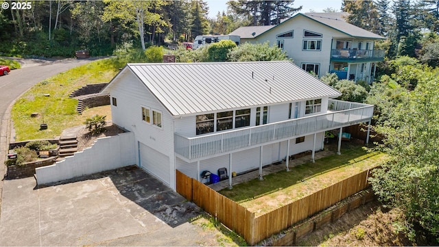 2144 Hamilton St, North Bend, OR 97459 - rear view of house with a garage, metal roof, a balcony, concrete driveway, and a standing seam roof
