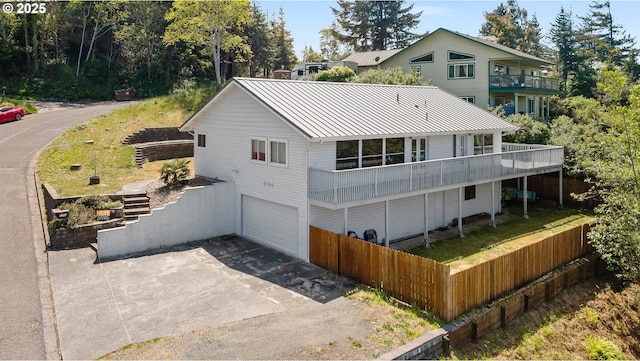 2144 Hamilton St, North Bend, OR 97459 - rear view of house featuring a balcony, a standing seam roof, an attached garage, fence, and metal roof