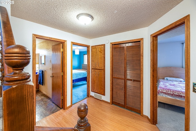 corridor featuring hardwood / wood-style flooring and a textured ceiling