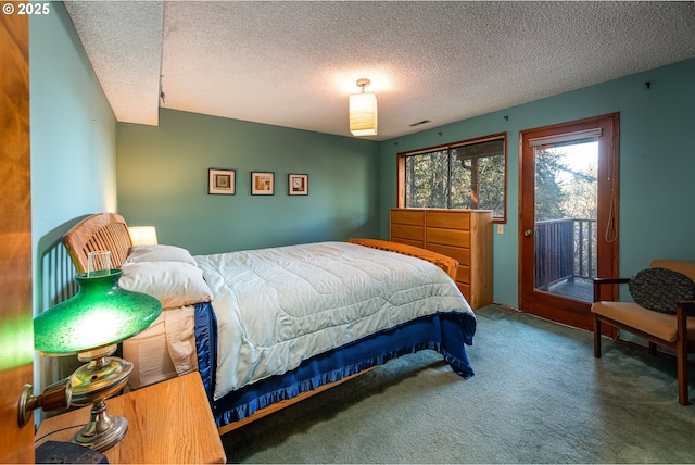 bedroom featuring access to outside, a textured ceiling, and carpet