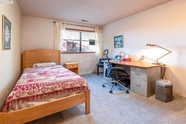 bedroom featuring light carpet and a textured ceiling