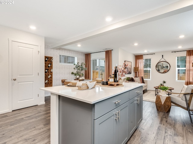 kitchen with gray cabinets, light hardwood / wood-style floors, and a center island