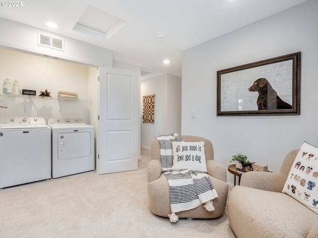 living area featuring light colored carpet and washing machine and clothes dryer