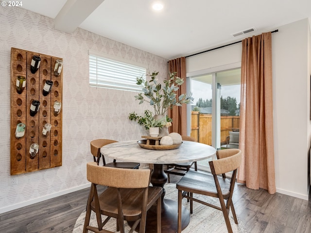 dining room featuring dark wood-type flooring and beamed ceiling