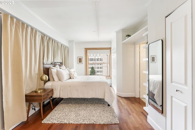 1005 SW Park Ave Unit 607, Portland, OR 97205 - bedroom featuring wood finished floors, ornamental molding, and baseboards