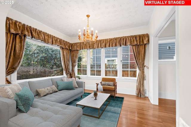 living room with a textured ceiling, hardwood / wood-style flooring, an inviting chandelier, and plenty of natural light