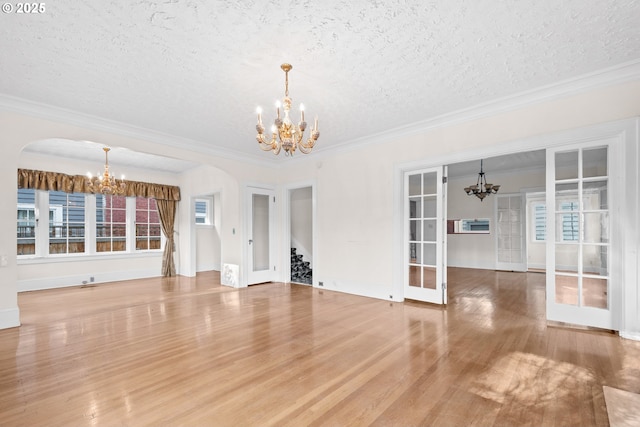 unfurnished living room with crown molding, french doors, and a textured ceiling