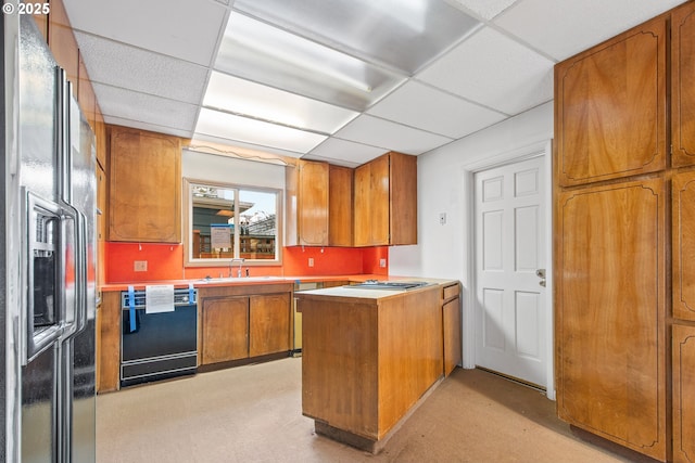 kitchen featuring a paneled ceiling, black dishwasher, refrigerator with ice dispenser, kitchen peninsula, and stainless steel gas cooktop