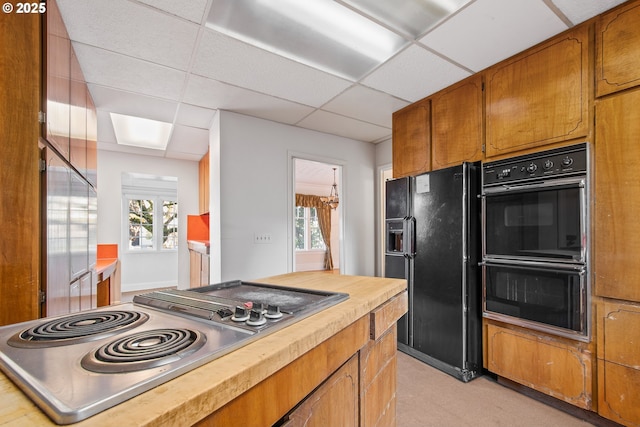 kitchen with a paneled ceiling and black appliances