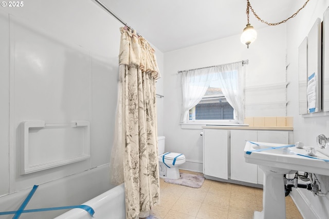 bathroom featuring shower / tub combo and toilet