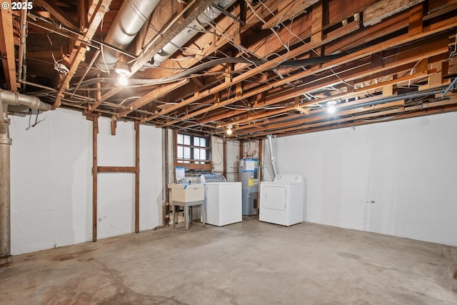 basement featuring electric water heater, independent washer and dryer, and sink