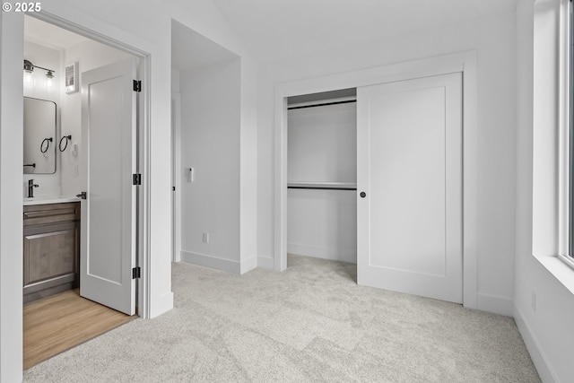 unfurnished bedroom featuring light colored carpet, a closet, baseboards, and visible vents