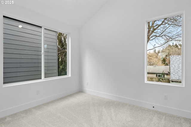 unfurnished room with lofted ceiling, carpet floors, and baseboards