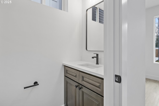 bathroom with wood finished floors, baseboards, and vanity