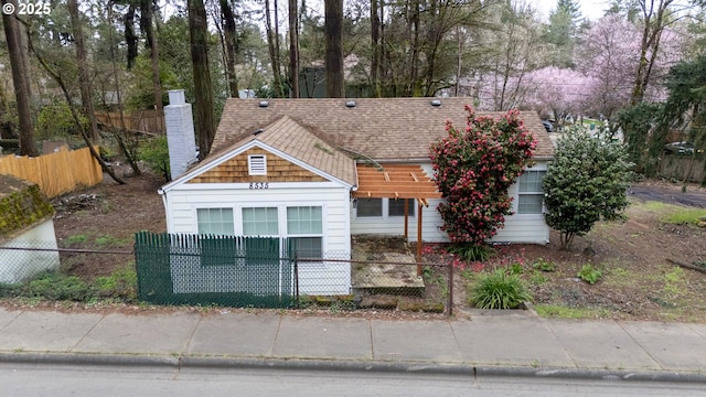8535 SW Oleson Rd, Portland, OR 97223 - view of front facade featuring a chimney, roof with shingles, and a fenced front yard