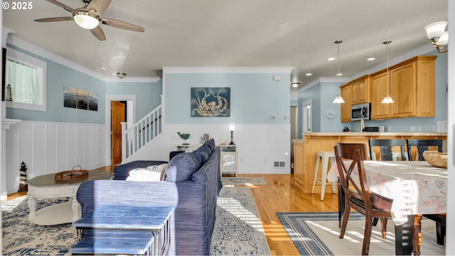 2781 SW Coast Ave, Lincoln City, OR 97367 - living room with a ceiling fan, ornamental molding, light wood-style floors, stairs, and recessed lighting