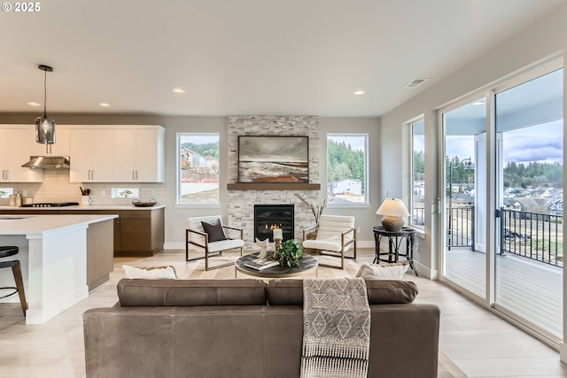 living room featuring recessed lighting, visible vents, a fireplace, and baseboards