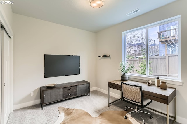 office featuring baseboards, visible vents, and light colored carpet