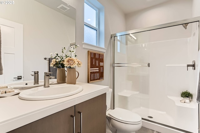 bathroom featuring visible vents, vanity, a shower stall, and toilet