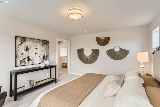 bedroom with baseboards and light colored carpet