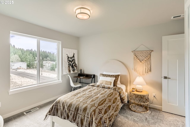 carpeted bedroom featuring visible vents and baseboards