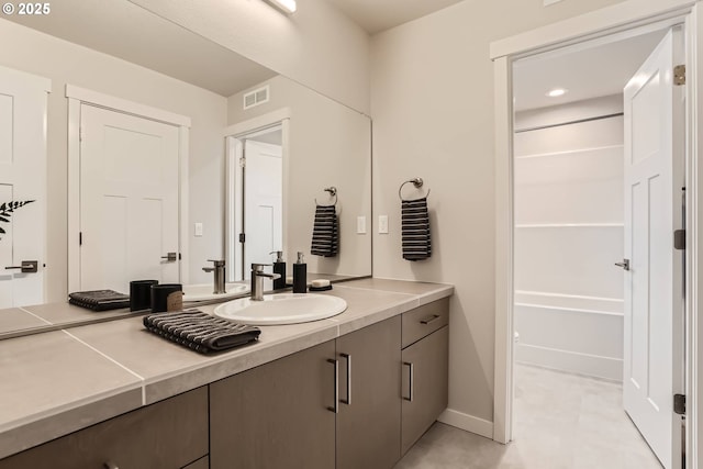 full bathroom featuring baseboards, washtub / shower combination, visible vents, and vanity