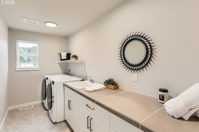 clothes washing area featuring cabinet space, visible vents, baseboards, independent washer and dryer, and a sink