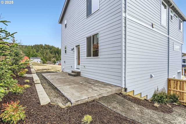 view of side of home featuring entry steps, a patio, and fence