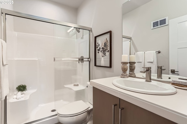 full bath with toilet, vanity, a shower stall, and visible vents