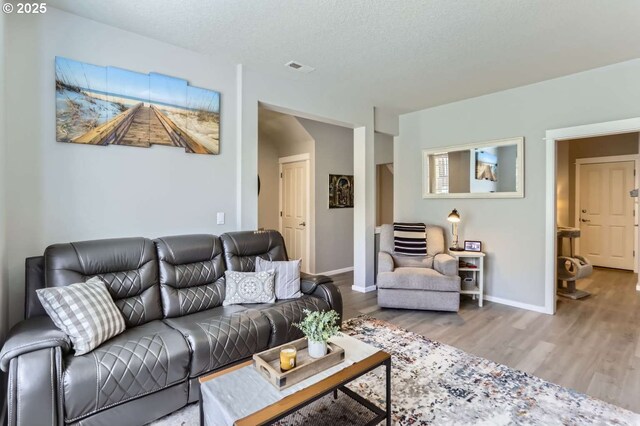 768 NE 70th Ave, Hillsboro, OR 97124 - living room with wood finished floors, baseboards, and a textured ceiling