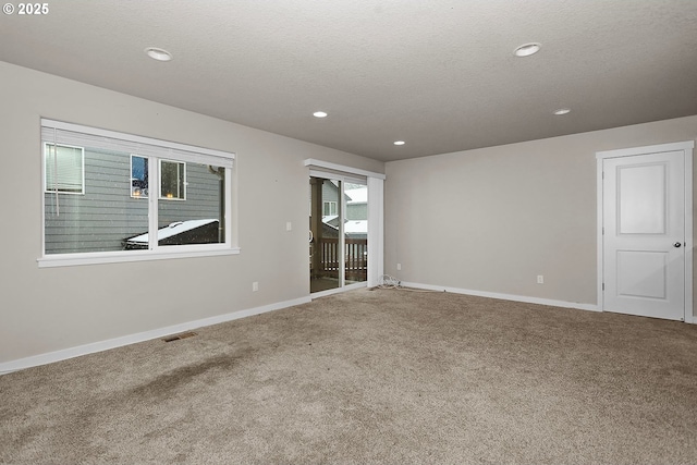 unfurnished room featuring carpet flooring and a textured ceiling