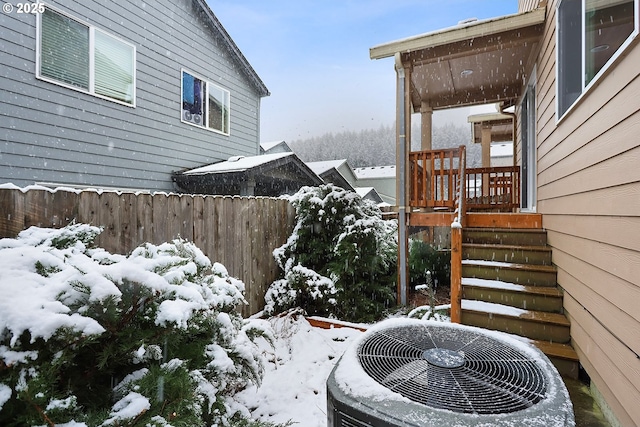 yard layered in snow featuring central air condition unit