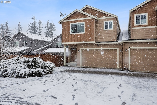 snow covered house with a garage