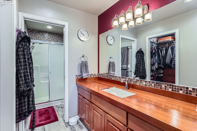 bathroom featuring hardwood / wood-style floors, vanity, and an enclosed shower