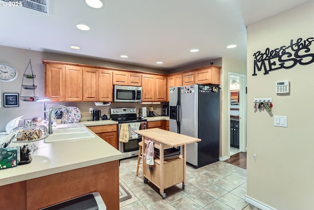 kitchen featuring light tile patterned floors, stainless steel appliances, and sink