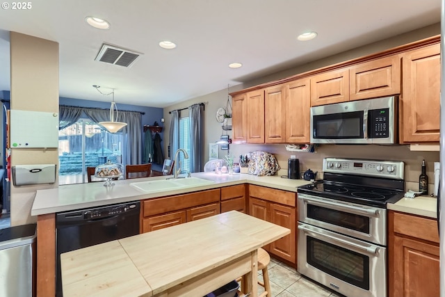 kitchen featuring sink, stainless steel appliances, kitchen peninsula, decorative light fixtures, and light tile patterned flooring