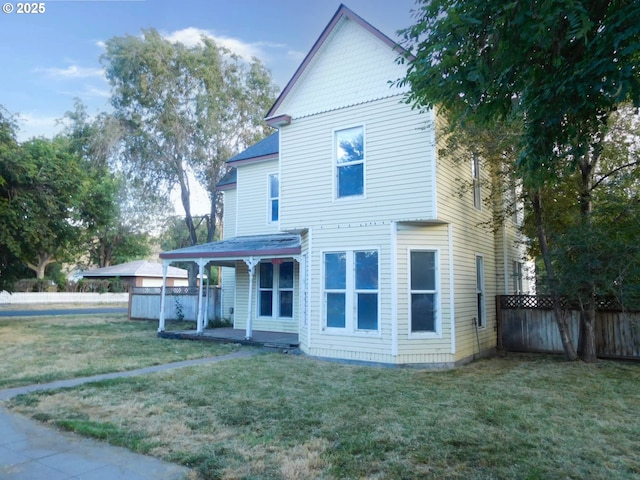 view of front facade featuring a front lawn, a patio area, and fence