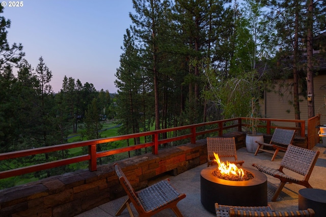 patio terrace at dusk featuring a fire pit