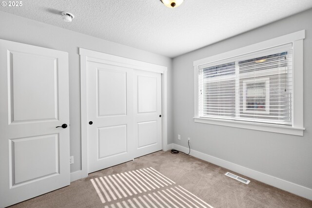 16849 SW Friendly Ln, Beaverton, OR 97007 - unfurnished bedroom with carpet floors, a closet, baseboards, and a textured ceiling