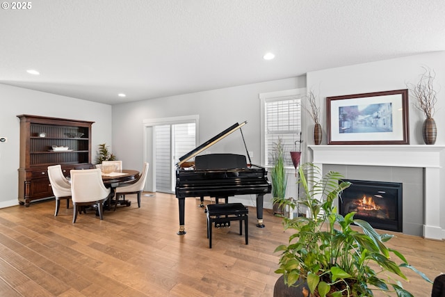 16849 SW Friendly Ln, Beaverton, OR 97007 - sitting room featuring light wood-style flooring, recessed lighting, a tiled fireplace, baseboards, and a textured ceiling