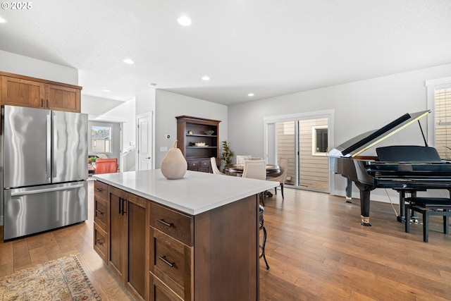 16849 SW Friendly Ln, Beaverton, OR 97007 - kitchen with freestanding refrigerator, a kitchen island, wood-type flooring, light countertops, and recessed lighting