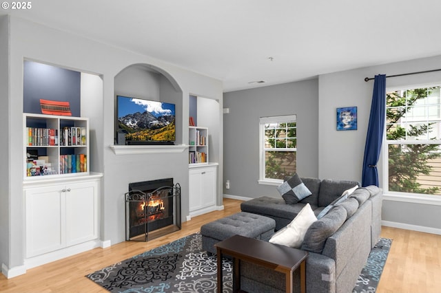 1020 SW 170th Ave Unit 203, Beaverton, OR 97003 - living area featuring light wood-style floors, a lit fireplace, and baseboards