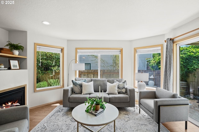 6309 NE 45th Ave, Portland, OR 97218 - living room featuring wood finished floors, healthy amount of natural light, a glass covered fireplace, recessed lighting, and a textured ceiling