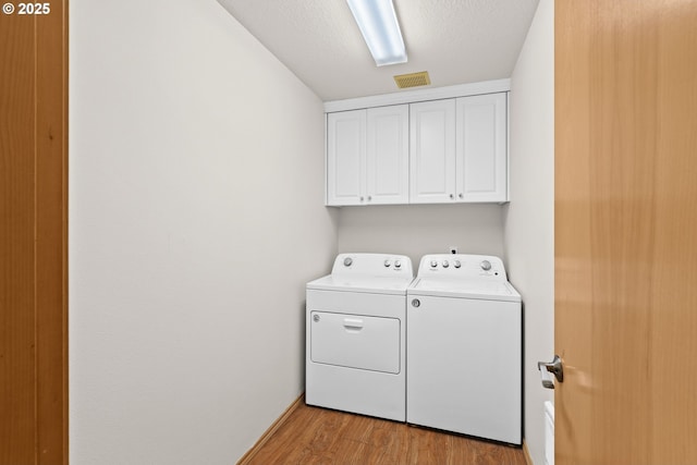 6309 NE 45th Ave, Portland, OR 97218 - laundry area featuring washing machine and clothes dryer, cabinet space, and light wood-type flooring
