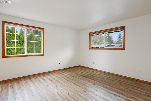 spare room with light wood-type flooring and baseboards