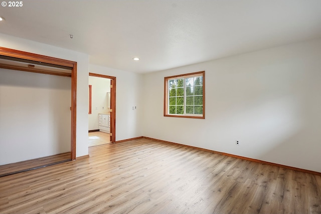 unfurnished bedroom with recessed lighting, connected bathroom, baseboards, and light wood finished floors