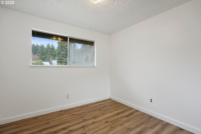 unfurnished room featuring baseboards, a textured ceiling, and wood finished floors