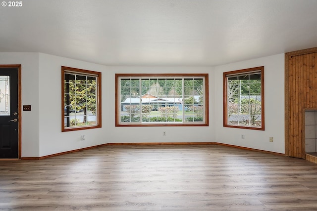 unfurnished living room with baseboards and wood finished floors